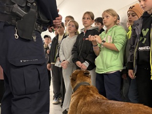 Dzieci rozmawiają z przewodnikiem psa służbowego