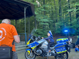 dziecko siedzące na policyjnym motocyklu