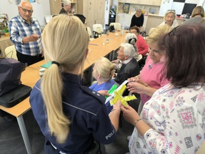 policjantka rozmawia z seniorami podczas spotkania