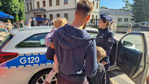 mężczyzna z dziećmi i policjantka przy radiowozie