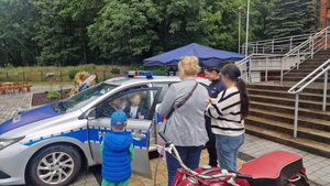 uczestnicy pikniku przy policyjnym radiowozie