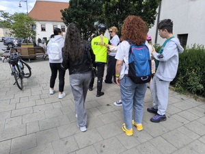 policjantka rozdaje przechodniom opaski odblaskowe