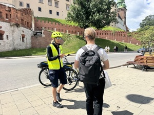 policjantka rozmawia z przechodniem i wręcza mu element odblaskowy