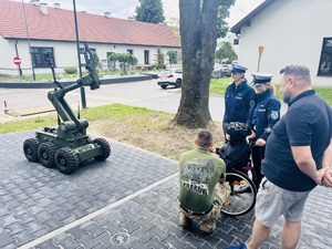 chłopiec w towarzystwie policjantów ogląda sprzęt używany przez kontrterrorystów