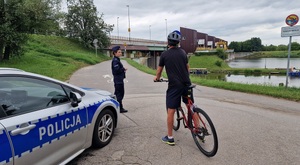 policjantka rozmawia z rowerzystą przy radiowozie