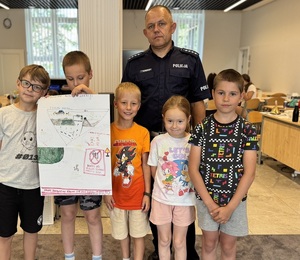 policjant pozuje do wspólnego zdjęcia z dziećmi