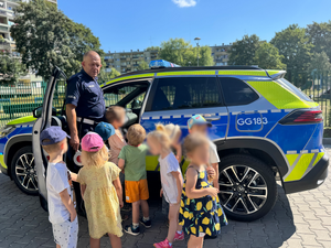 policjant pokazuje dzieciom wnętrze radiowozu