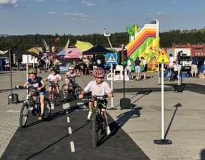 dzieci poruszające się na rowerach po przygotowanym miasteczku