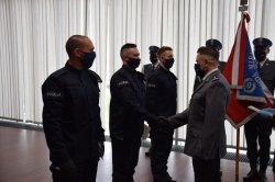 policjant przyjmuje legitymację służbową od zastępcy komendanta