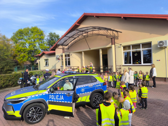 dzieci zgromadzone wokół policyjnego radiowozu