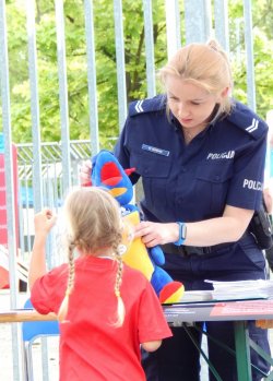 policjantka rozmawia z dziewczynką przy stoisku policyjnym