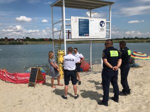 Policjanci, Strażnicy Miejscy oraz przedstawicielka Urzędu Miasta w trakcie działań podejmowanych w celu zwiększenia bezpieczeństwa nad wodą.