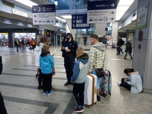 policjantka na Dworcu Głównym rozmawia z pasażerami pociągu
