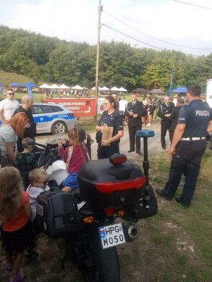 dzieci wokół policyjnego motocykla, w pobliżu policjantka prewencji i policjant drogówki