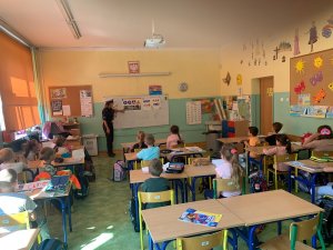 policjantka pokazuje dzieciom znaki drogowe na tablicy edukacyjnej