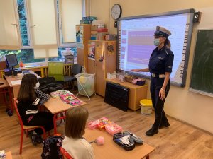 Policjantka w sali lekcyjnej prowadzi zajęcia dla dzieci