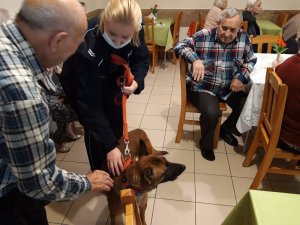 policjantka z psem służbowym w otoczeniu podopiecznych Domu Pomocy Społecznej