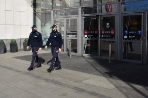 policjanci kontrolujący przestrzeganie obostrzeń sanitarnych w galerii handlowej