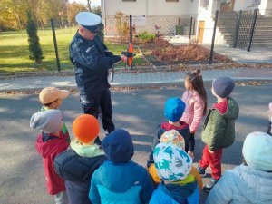 policjant pokazuje dzieciom urządzenie wykorzystywane w swojej pracy