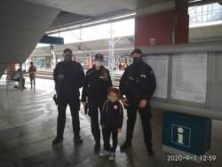dwóch przedstawicieli straży ochrony kolei i jedna policjantka w maseczkach pozują do zdjęcia z dziewczynką w maseczce na jednym z peronów dworca kolejowego w krakowie