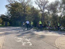 policjant wraz z grupą dzieci jadą na rowerach po ścieżce rowerowej