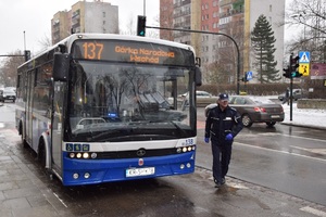 Policjant koło autobusu po wręczeniu kalendarza kierowcy.