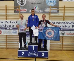 trzech mężczyzn stojących na podium zawodów z dyplomami i medalami