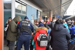 policjant na krakowskim dworcu w tłumie podróżnych