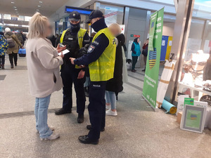 Dwaj policjanci rozmawiają z kobietą