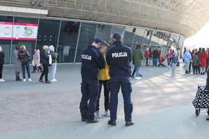 Dwaj policjanci rozmawiają z kobietą pod Tauron Areną
