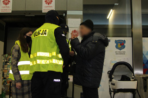 Dwaj policjanci i wolontariuszka rozmawiają ze starszym mężczyzną