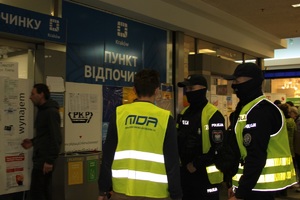 Policjanci rozmawiają z wolontariuszem pod punktem pomocy