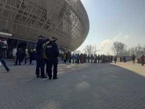 Dwaj policjanci wskazują drogę kobiecie pod Tauron Areną