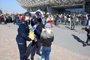 chłopiec otrzymuje od krakowskich policjantów kolorowanki i słodycze