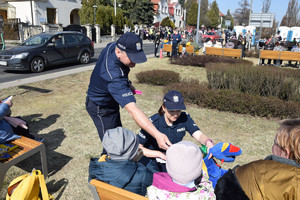 pod konsulatem Ukrainy policjanci rozmawiają z uchodźcami i rozdają ulotki informacyjne oraz słodycze dla dzieci