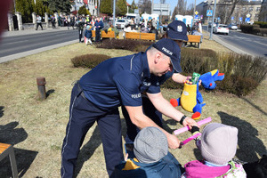 pod konsulatem Ukrainy policjanci wręczają dzieciom słodycze i opaski odblaskowe