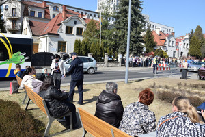 policjant wręcza dzieciom słodycze, a dorosłym uchodźcom ukraińskim ulotki informacyjne