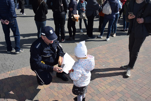 policjant wręcza dziewczynce kolorowankę