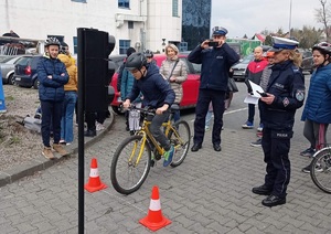 policjant i policjantka nadzorują przejazd rowerowy po torze przeszkód przy Parku Wodnym w Krakowie