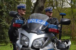 dwaj policjanci z ruchu drogowego stoją przy policyjnym motocyklu