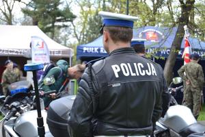 policjant stojący przy policyjnym motocyklu