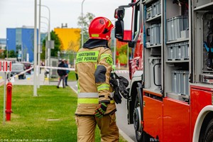 strażak stojący przed wozem strażackim