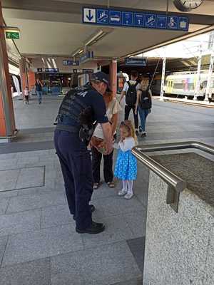 Policjant częstuje dziewczynkę cukierkiem