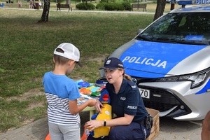 policjantka rozmawia z dzieckiem o bezpiecznym wypoczynku nad wodą