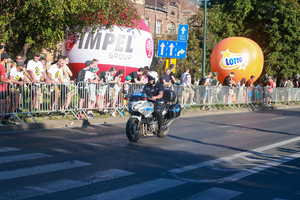 policjant na motocyklu zabezpiecza wyścig kolarski