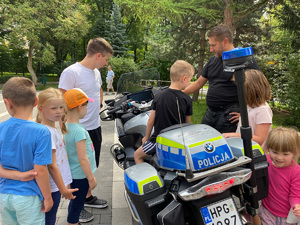 dzieci oglądają policyjny motocykl w obecności policjanta