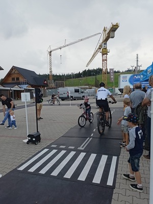 policjant patrolu rowerowego oraz dziecko na rowerze na mini miasteczku drogowym