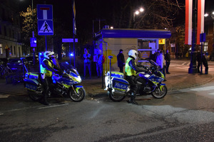 policjanci drogówki na motocyklach w rejonie ul. Piłsudskiego w tle ludzie oraz budynek handlowo-usługowy