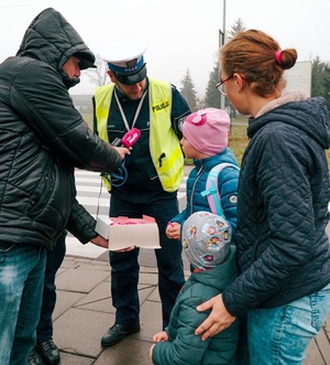 dziennikarz radiowy zadaje pytania kobiecie z dziećmi obok stoi policjant drogówki