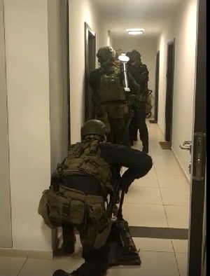 Zdjęcie przedstawiające siłowe wejście policjantów do mieszkania jednej z osób zajmujących się sutenerstwem